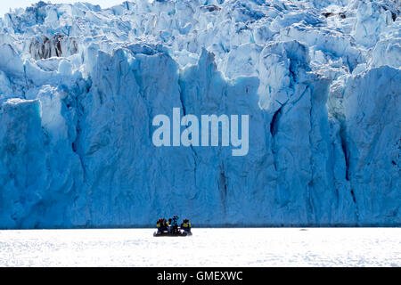 Der gigantische Vorderseite des Rijpbreen-Gletschers in Svalbard mit einer Gruppe von Touristen bewundern die Schulnote Zodiac. Stockfoto