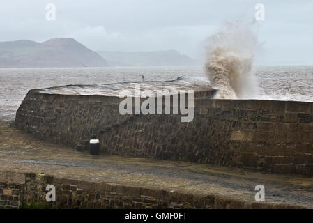 Wellen, die über The Cobb bei Lyme Regis auf Dorsets Jurassic Coast während eines Sturms. Stockfoto