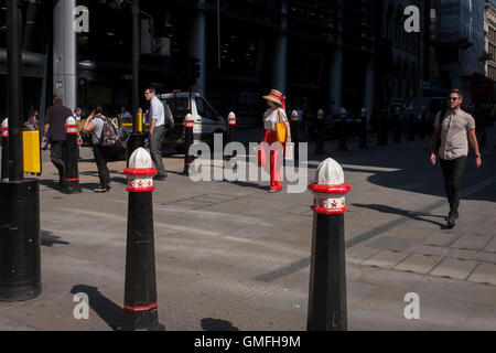 Eine exzentrisch gekleideten Dame Spaziergänge Cannon Street in der City of London, UK. Stockfoto