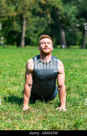 Junger Mann, Übungen auf dem Rasen im park Stockfoto