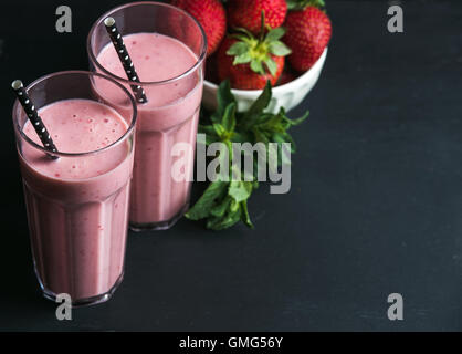 Erdbeeren und Minze Smoothie in hohe Gläser, Bawl mit frischen Beeren auf rustikalen Holz dunkel Stockfoto