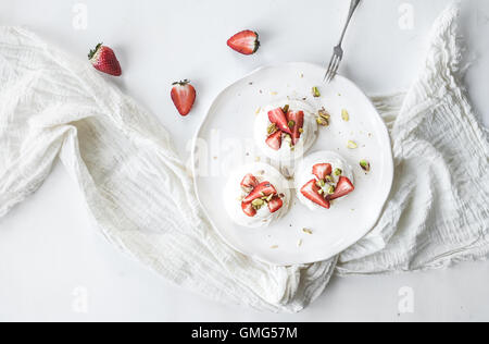 Kleine Erdbeeren und Pistazien Pavlova Baiser Kuchen mit Mascarpone-Creme Stockfoto