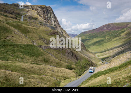 Bus klettern die Straße hinauf Honister pass, Gebirgspass im englischen Lake District National Park, UK. Stockfoto