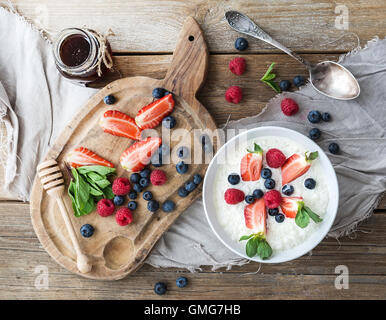 Gesunden Frühstücks-Set. Reis-Müsli oder Porridge mit Beeren und Honig Stockfoto