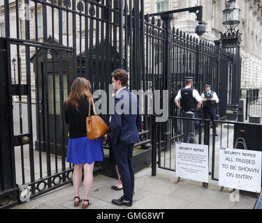 Bewaffnete Polizei und Besucher draußen vor dem Tor der Downing Street in London England Stockfoto