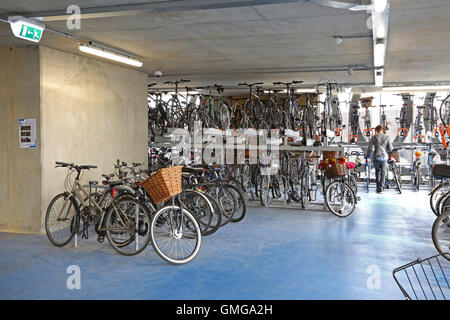 Ein Radfahrer Räder ihr Fahrrad um einen Parkplatz in einer neuen mehrstöckigen Bikepark in Cambridge, UK zu finden. Stockfoto