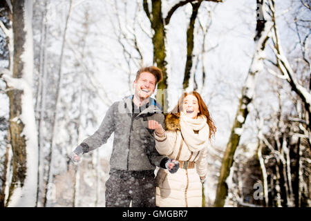 Junge Paare, die Spaß im Schnee im park Stockfoto