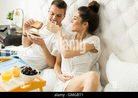 Junges Liebespaar im Bett frühstücken Stockfoto