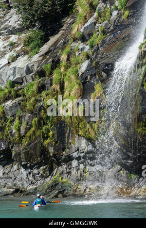 Zwei Kajakfahrer Ruhe vor einem kleinen Wasserfall im Prinz-William-Sund. Stockfoto