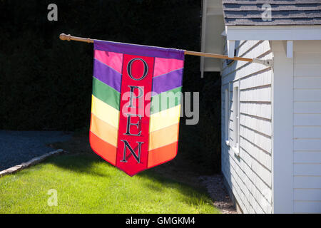 Schild "geöffnet" auf Flagge vor einem Geschäft. Stockfoto