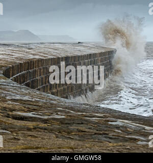 Wellen, die über The Cobb bei Lyme Regis auf Dorsets Jurassic Coast während eines Sturms. Stockfoto