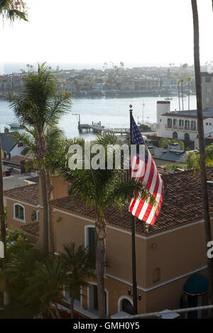 Amerikanische Flagge fliegt über Corona del Mar Häuser eine Nachbarschaft in der wohlhabenden Stadt Newport Beach mit Blick auf Newport Bay Stockfoto