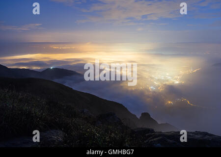 Lichter der Tung Chung Neustadt unter Wolken auf Lantau Island, gesehen vom Lantau Peak in Hong Kong, China. Stockfoto