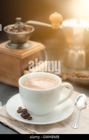 Kaffee Tasse und Vintage Kaffeemühle mit Kaffeemaschine Topf auf alten Holztisch Stockfoto