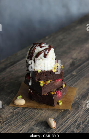 Himbeere Pistazien dunkle Schokolade Brownie Eisbecher mit hausgemachtem Vanilleeis und Schokoladensauce Stockfoto