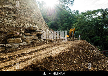 ein Bagger auf einer Hügel-Autobahn-Baustelle in der Nähe von Dakshinkali Tempel unterwegs Bhaise-Kathmandu in Nepal geparkt Stockfoto