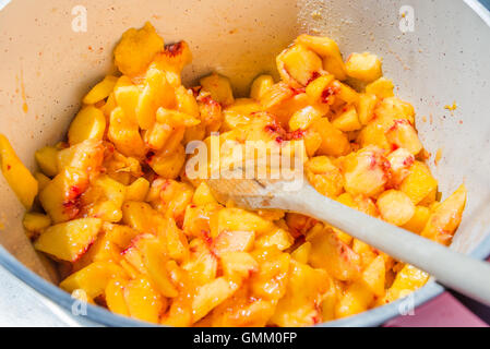 Draufsicht auf einen Topf voll mit geschnittenen Pfirsiche. Hausgemachte Pfirsich Marmelade kochen. Stockfoto