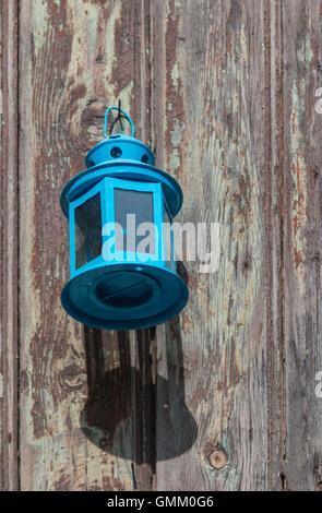 Vintage blaue Laterne hängenden gegen eine Holztür Stockfoto