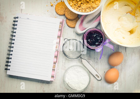 Leere Rezept Notebook mit Käse Kuchen Zutaten auf einem weißen Hintergrund Holz. Stockfoto