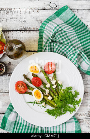 Warmer Salat von gebratenem Spargel, Feta-Käse, Tomaten und Eiern. Ansicht von oben Stockfoto