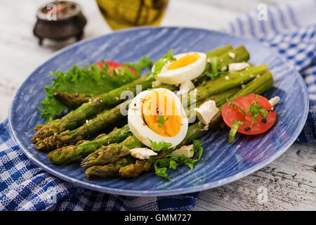 Warmer Salat von gebratenem Spargel, Feta-Käse, Tomaten und Eiern. Stockfoto