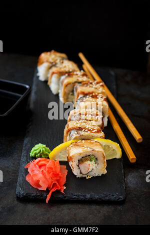 Traditionelles japanisches Essen - Sushi, Brötchen und Sauce auf einem schwarzen Hintergrund. Stockfoto