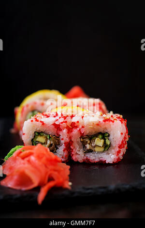 Traditionelles japanisches Essen - Sushi, Brötchen und Sauce auf einem schwarzen Hintergrund. Stockfoto