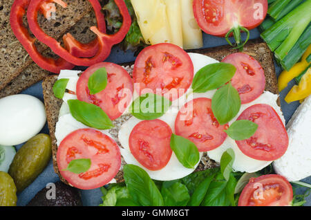 gesunde Sandwich mit Mozzarella, Tomaten und Basilikum auf Tisch Stockfoto