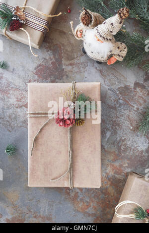 Weihnachten Hintergrund mit Geschenken und Santa Claus Puppe Figur auf rustikalen Hintergrund. Draufsicht, getönten Jahrgang Bild, leere spac Stockfoto