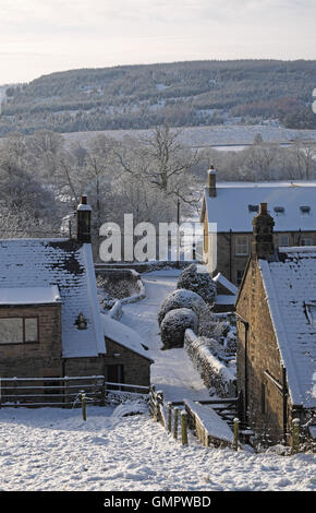 Eine schneebedeckte Lane, Falstone Dorf, Northumberland, England, UK. Stockfoto