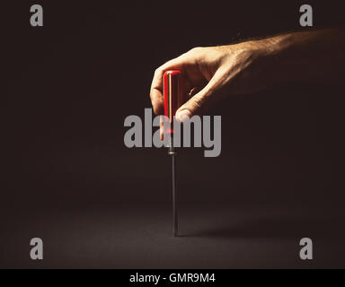 Konzeptuelle Komposition, Mannes Hand mit einem Schraubendreher. Stockfoto