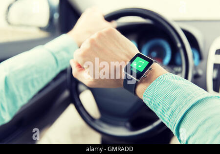 Hände mit Musik-Ikone auf Smartwatch Auto fahren Stockfoto