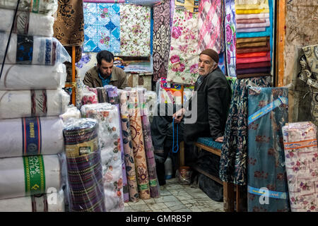 Kaufmann im Stoff-Shop mit Tasbih, Gebetsketten, auf dem Basar in Isfahan, Iran. Stockfoto