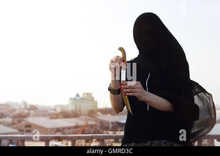 Mädchen in schwarz mit einer orientalischen Dolch Stockfoto