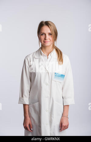 Krankenschwester oder junge Arzt stehen und blickte in die Kamera. Isoliert auf weißem Hintergrund. Stockfoto
