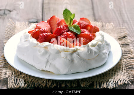 Kuchen-Pavlova mit Erdbeeren auf Holztisch Stockfoto
