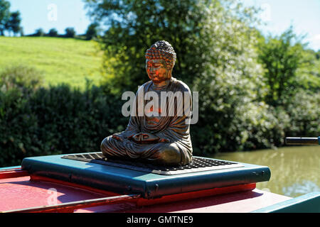 Statue des sitzenden Buddha auf Dach des Kanalboot Stockfoto