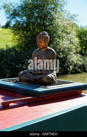 Statue des sitzenden Buddha auf Dach des Kanalboot Stockfoto