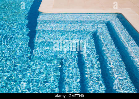Schwimmbad-Schritte in der Morgensonne mit Schatten betont ihre schönen geschwungenen Formen. Die Schritte sind Fliesen mit til Stockfoto