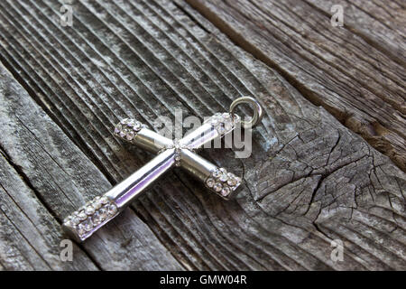 Silberne christlichen Kreuz auf hölzernen Hintergrund Stockfoto