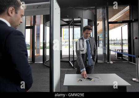 Mann am Flughafen Sicherheitsschleusen Außerbetriebnahme Telefon und Schlüssel Stockfoto