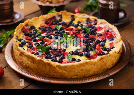 Französischer Tarte (Flan) mit Beeren und Vanillesauce. Stockfoto