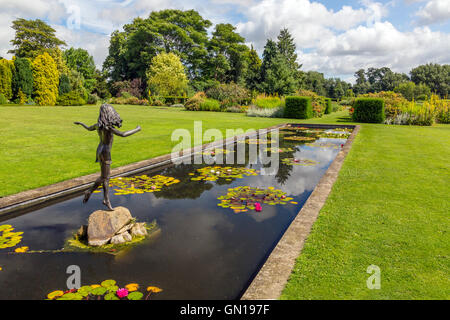 Die bunten Seerosenteich mit einer Statue des jungen Mädchens an der Waterperry Gärten, Oxfordshire, England, UK Stockfoto