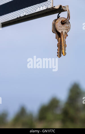 Paar Hausschlüssel gefunden aufgehängt hängend von einem Roadsign, wahrscheinlich vom Finder in der Hoffnung, dass die Verlierer sehen wird. Stockfoto