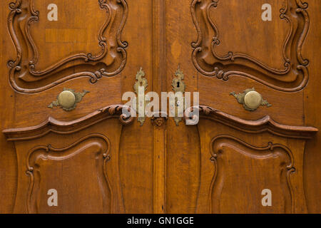 Wunderschön geschnitzte Holztür mit Metall Türgriffe und dekorierten Schlüssellöcher. Stockfoto