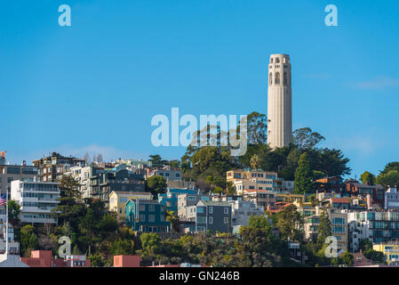 Coit Tower und der Bay Bridge aus der Kreuzung von Lombard & Hyde Street in San Francisco, Kalifornien Stockfoto