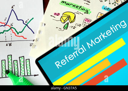 Tablet mit Worten Referral Marketing auf einem hölzernen Hintergrund. Stockfoto