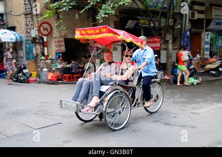 Hanoi, Vietnam - 20. November 2015. Touristen erkunden Hanois Altstadt in einem Cyclo. Stockfoto