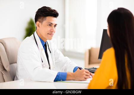 junger Arzt im Gespräch mit seinem Patienten im Büro Stockfoto