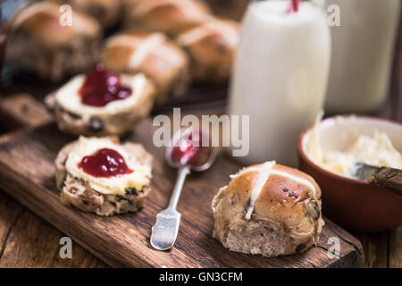 cremige Tee, heiße Kreuz Brötchen mit Marmelade und Clotted cream Stockfoto